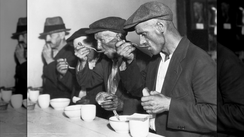 Men eat bread and soup in Depression-era