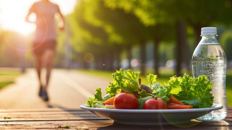 Salad on a plate with a water bottle, with a runner in the background