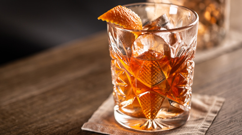 An old fashioned whiskey cocktail sitting on a coaster.