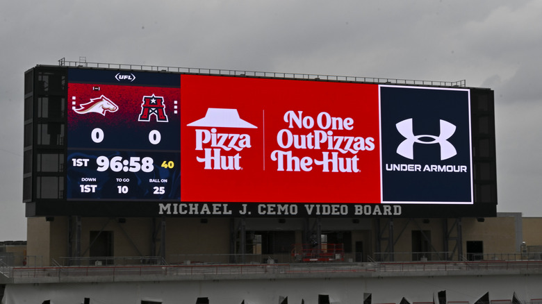 Pizza Hut ad on a stadium video board with slogan "No One OutPizzas The Hut"