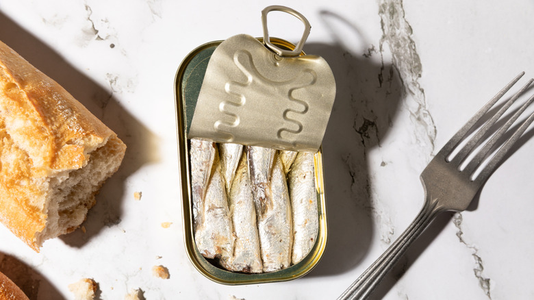 An open can of sardines on a counter.