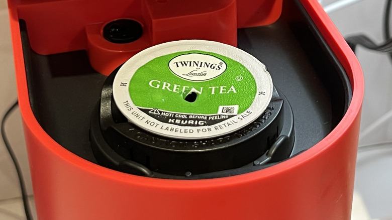 A Twinings green tea pod in a red Keurig machine