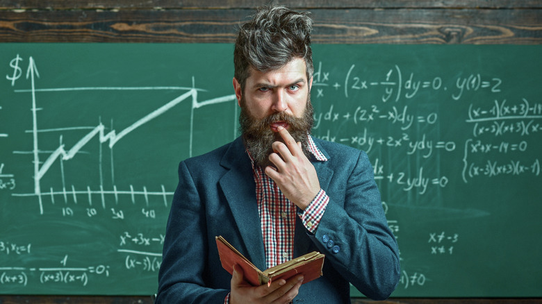 A math professor stands in front of a chalkboard