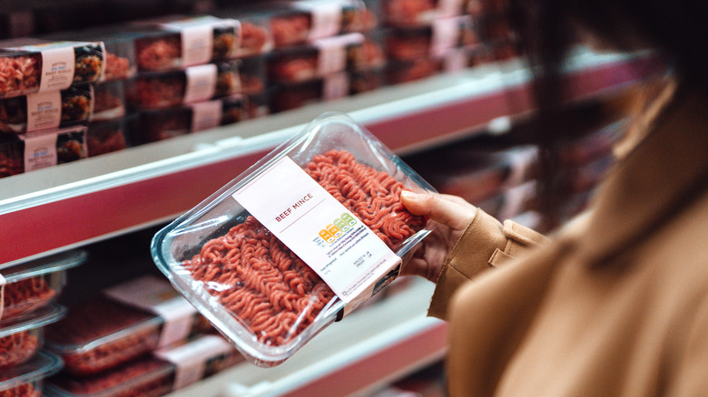 person looking at ground beef in the supermarket