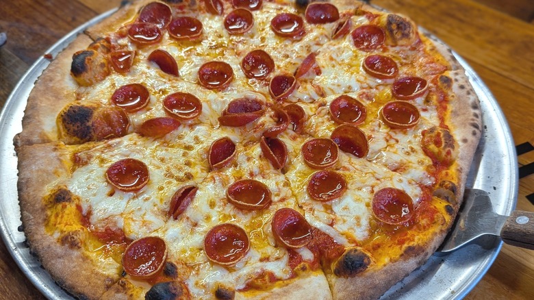 Pizza pie with cup and char pepperoni