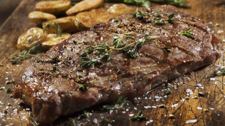 Baseball steak with herbs and flaky salt on board