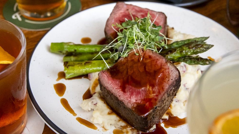 Baseball steak with asparagus on a white plate