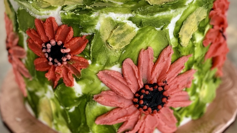 Cake with red and pink flowers made using the back of a spoon.