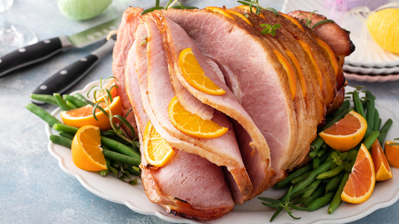 spiral-cut ham with orange slices and green beans