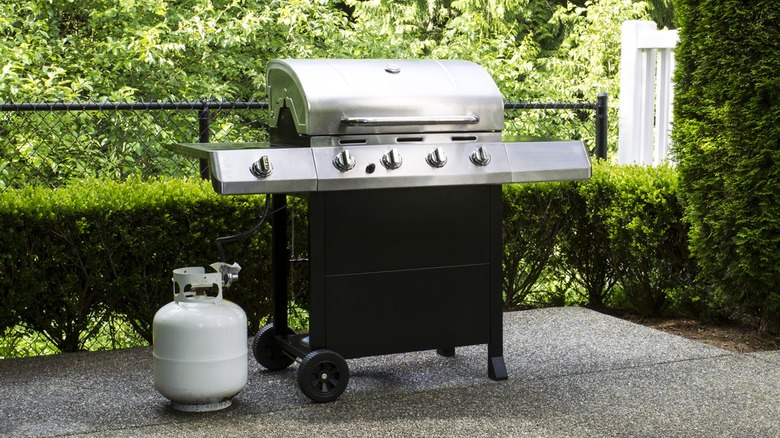 An outdoor gas grill with a propane tank
