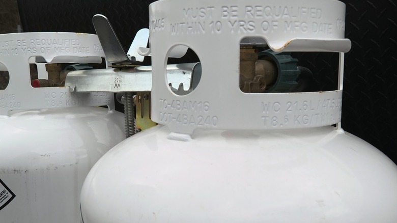 Two propane tanks with requalification warning stamps