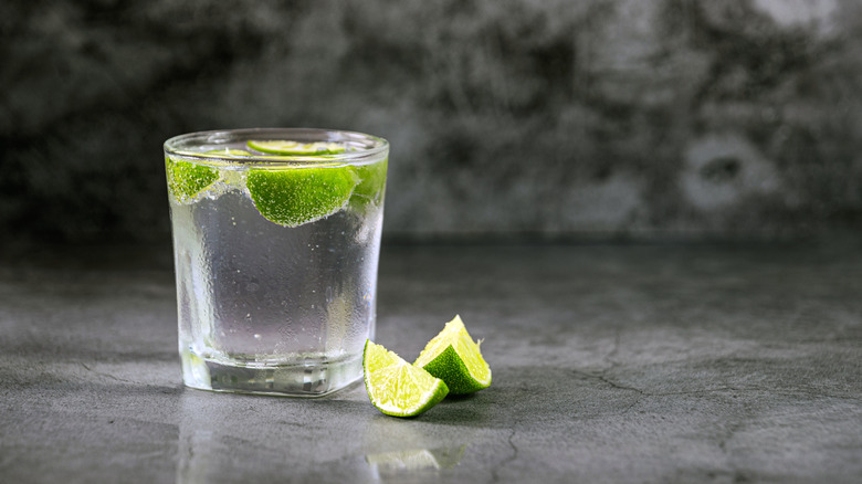 Neat vodka in glass with lime wedges