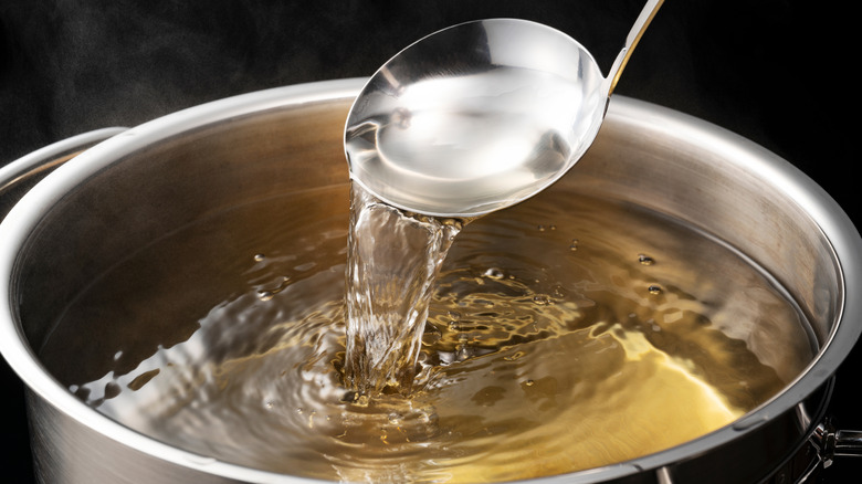Dashi in a silver pot with a ladle