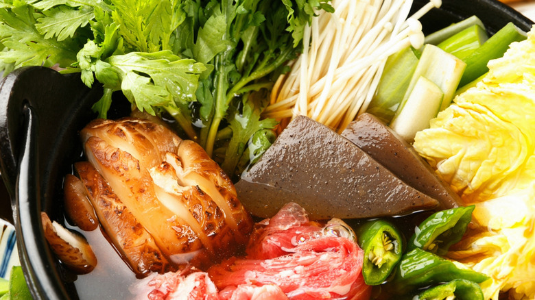 Japanese hot pot with various ingredients and garnishes