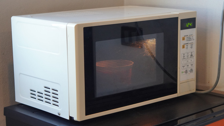 Microwave with a container cooking inside.