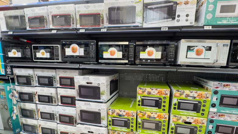 Microwaves on a store shelf.
