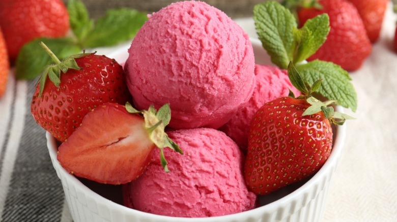 Bowl of strawberry sorbet garnished with halved and whole strawberries