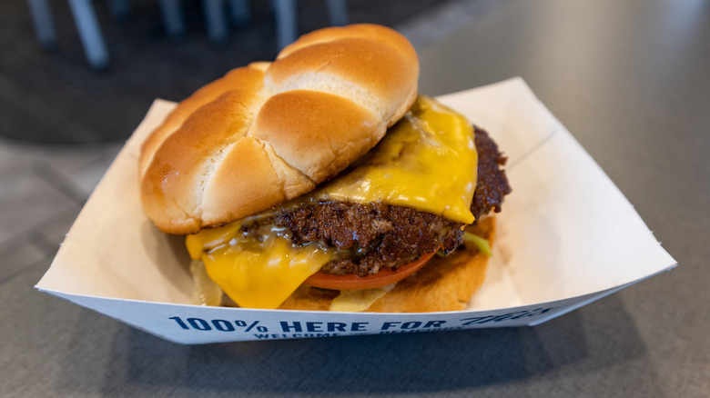 Culver's double cheeseburger in paper boat with melted cheese on it.