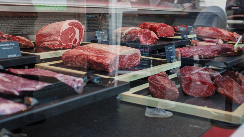 Assorted meats behind glass at a butcher shop