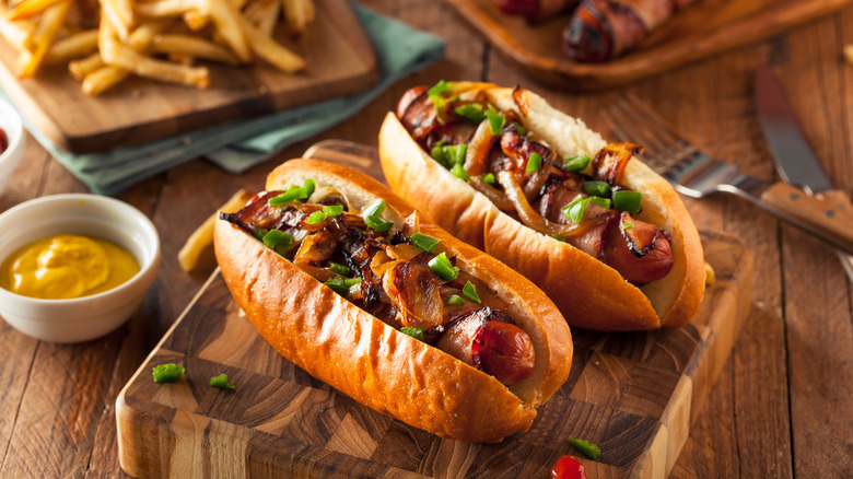 Bacon-wrapped hot dogs on a wooden block
