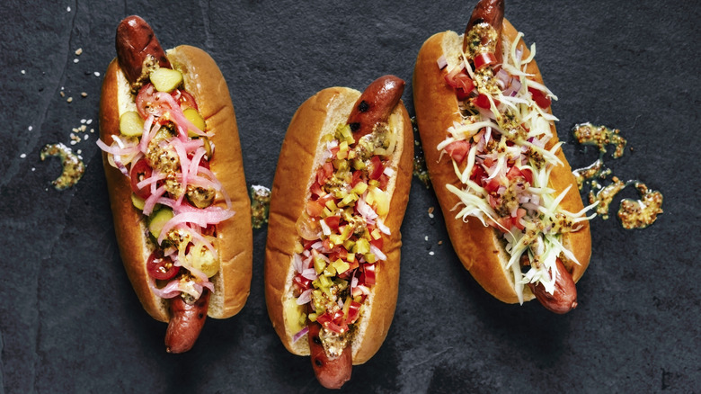 Hot dogs with toppings on a slate background