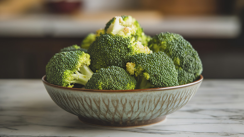 Broccoli in a bowl on a marble countertop.
