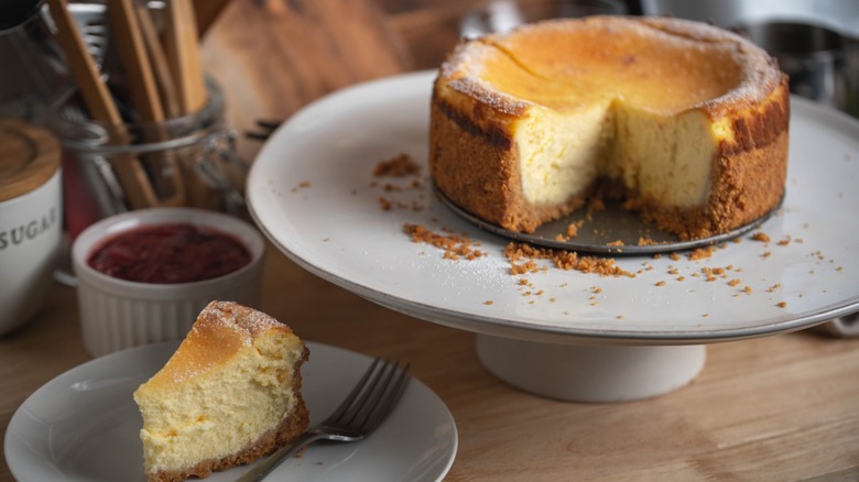 A slice of New York City-style cheesecake taken from the whole.