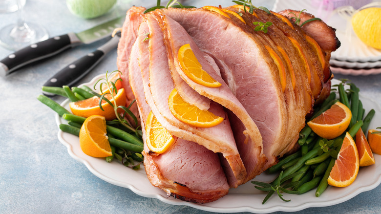spiral-cut ham with orange slices and green beans