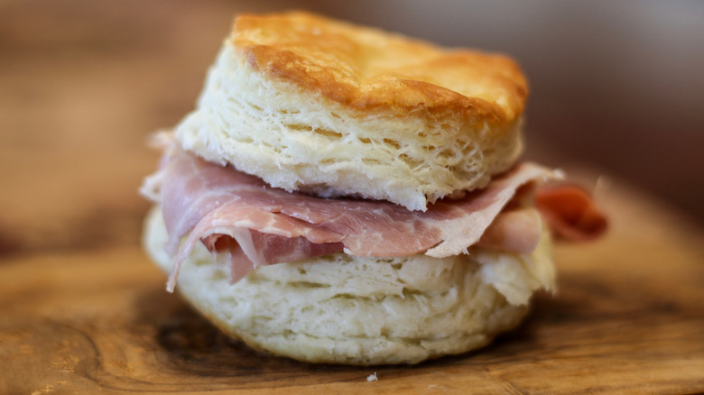 biscuit with country ham on a wooden surface