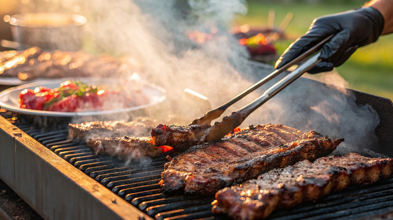 Person grilling ribs outside