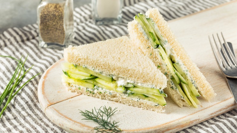 Cucumber sandwich cut diagonally on wood board