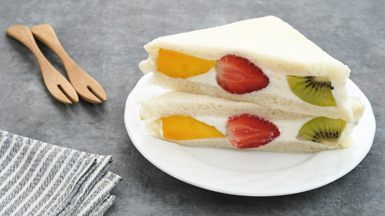 Two diagonal cut Japanese fruit sandwiches on a white plate