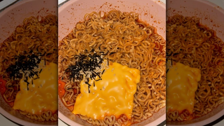 A slice of American cheese melting into Buldak instant ramen with seaweed seasonings