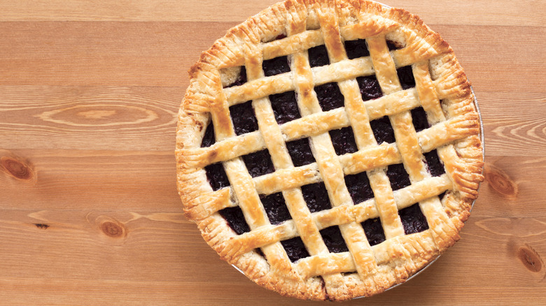 Overhead view of a blueberry pie on a wooden table