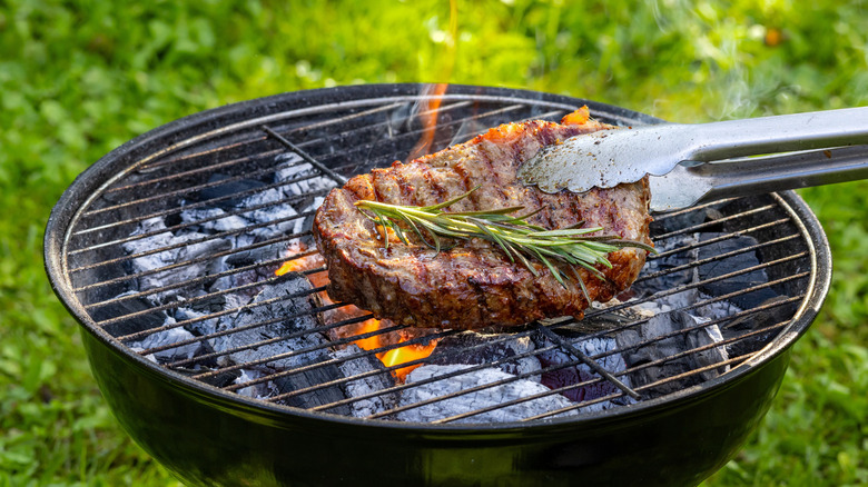 Grilling steak on a charcoal grill