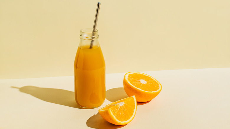 Orange juice glass with fresh oranges