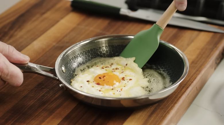 Gordon Ramsay removes egg from pan.