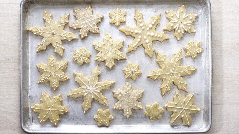 Snowflake-shaped sugar cookies sitting on a tray.