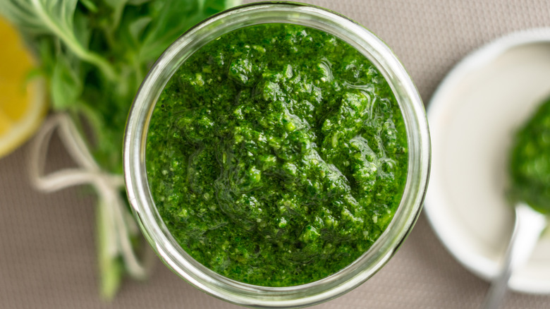 Top view of glass jar of basil pesto