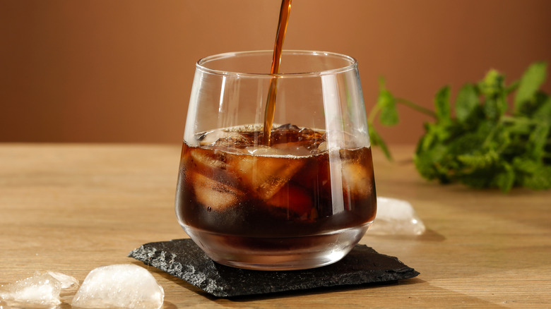 Pouring a glass of cold brew coffee with ice