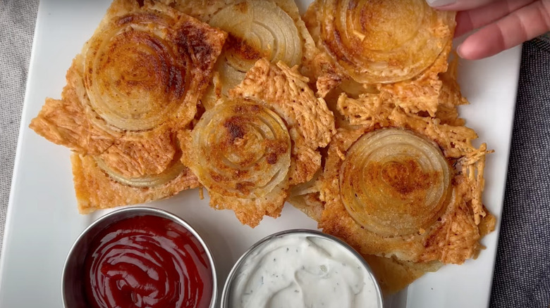 Viral onion chips on white plate with ketchup and ranch