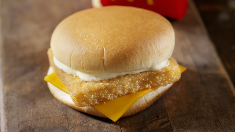 A Filet-O-Fish sandwich rests on a wooden surface