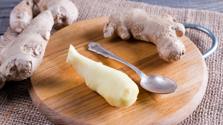 Spoon-peeled ginger root on a cutting board