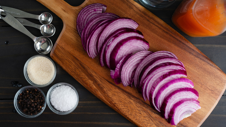 Sliced red onion sitting on a wooden cutting board