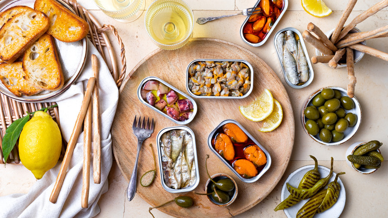 different kinds of canned fish on a wooden plate