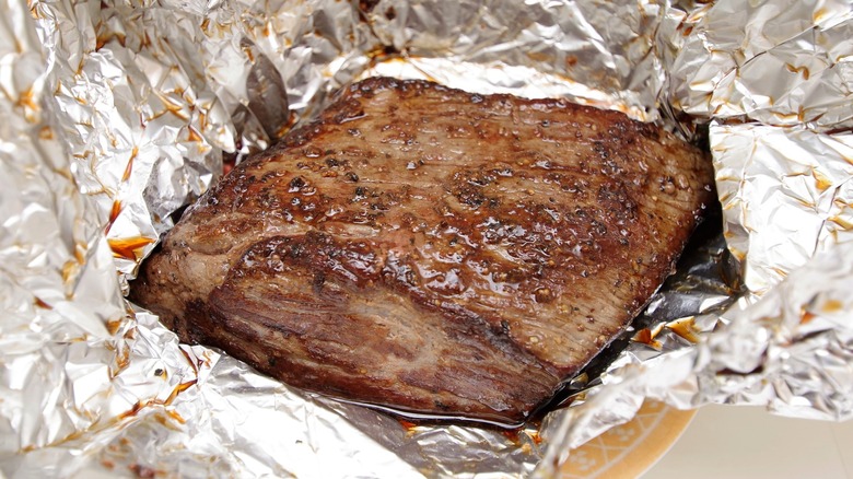 Roast beef wrapped in foil with juices