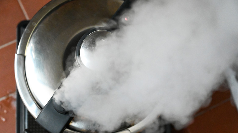 Pressure cooker releasing steam