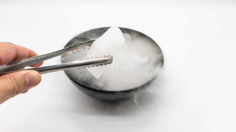 hand holding dry ice with tongs