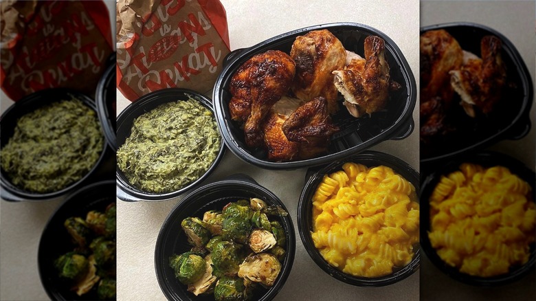 Black plastic bowls of vegetables, macaroni cheese, and roast chicken
