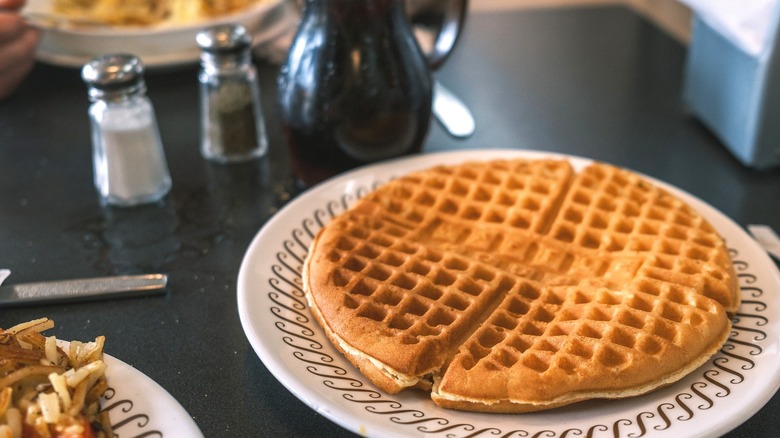 A Waffle House waffle with syrup and silverware